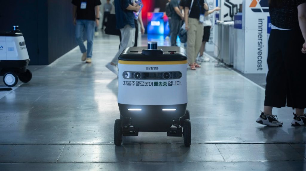 pexels photo 32778343 2 Autonomous delivery robot navigating indoors during a technology event.