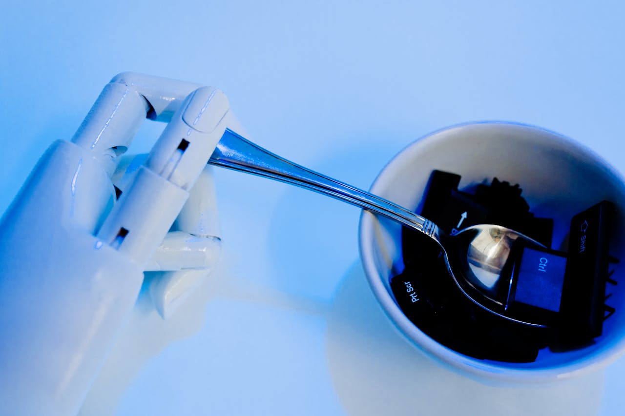 A robotic hand holding a spoon above a bowl with keyboard keys, showcasing technology themes.